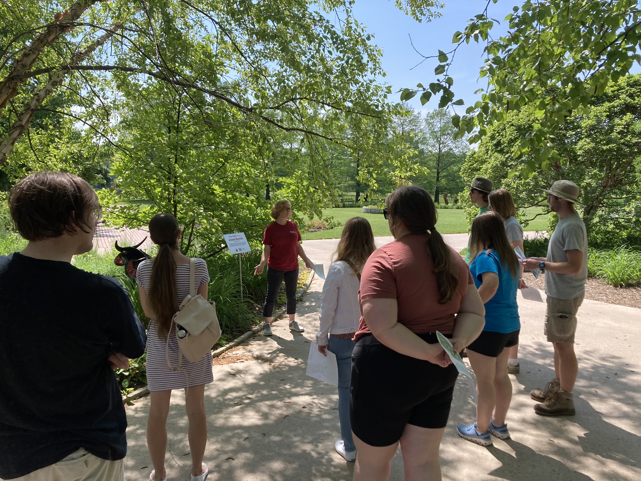 Entomology staff member Anita stands before a group of visitors, leading a tour about insects in the gardens.