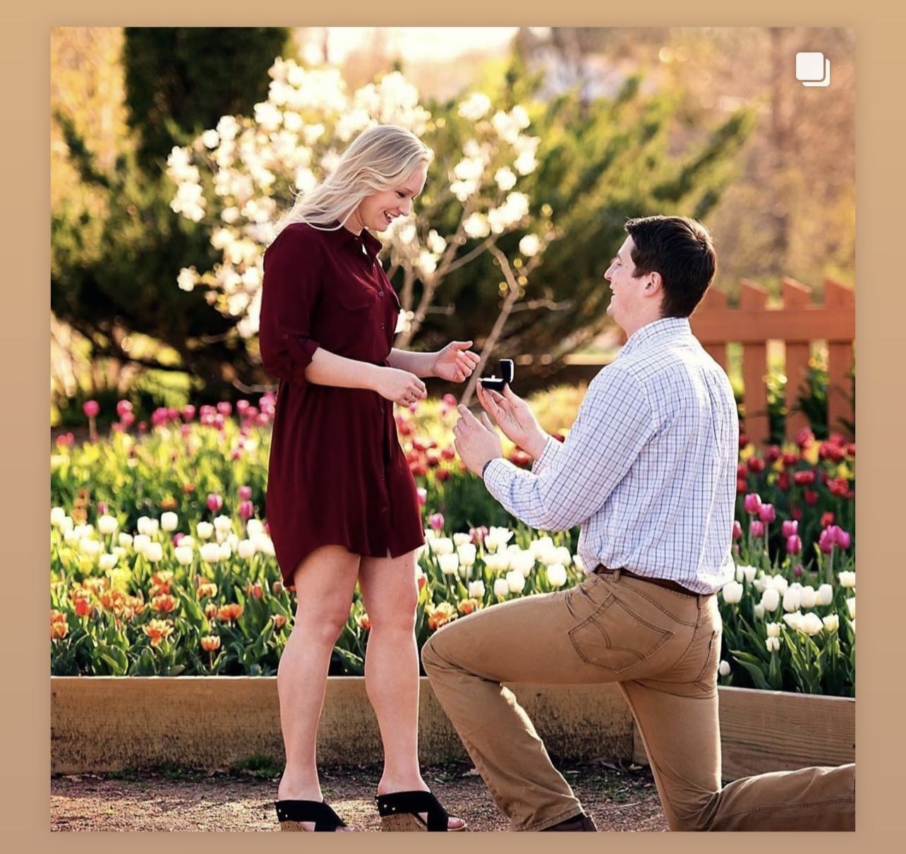 A man is down on one knee, holding a ring out to a woman. She, happily, accepts.