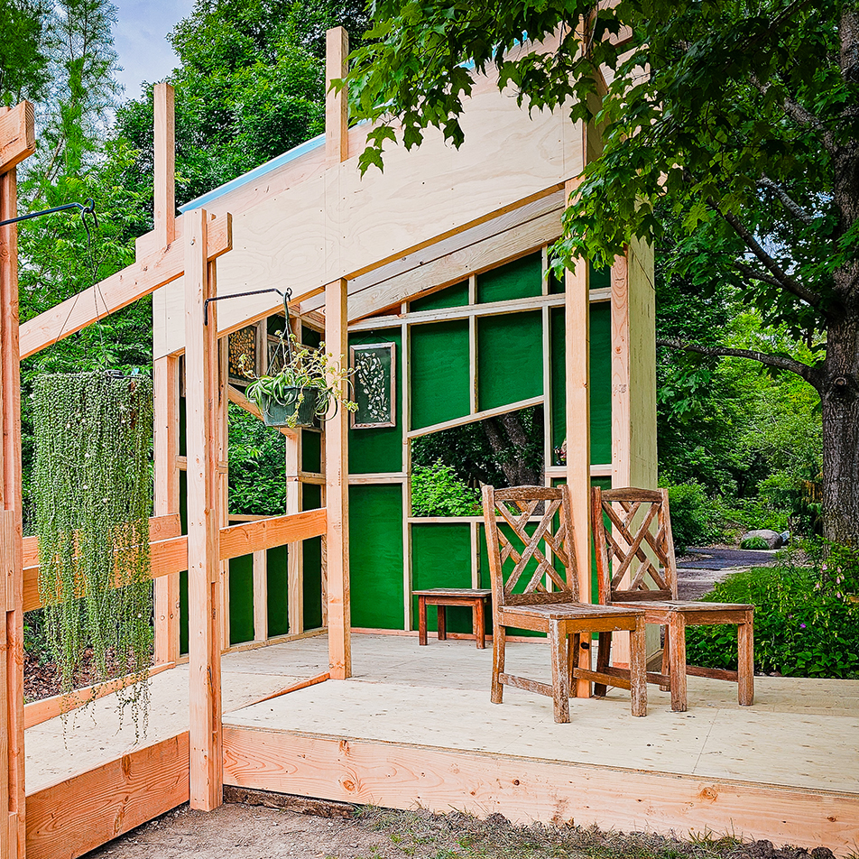 Wooden playhouse with chairs and hanging plants
