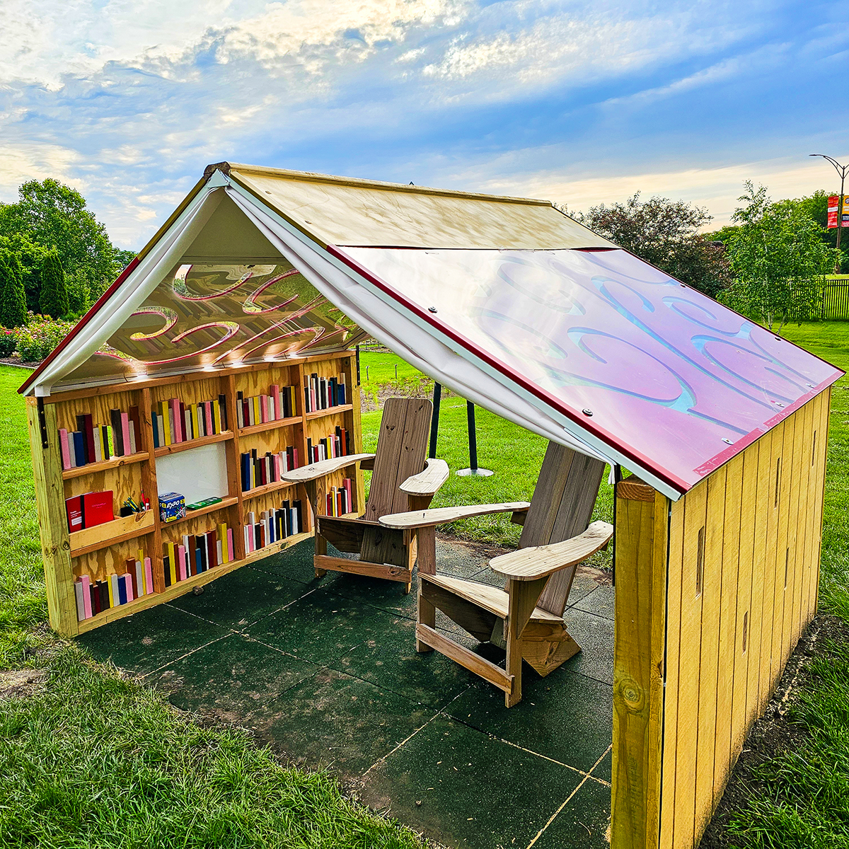 Playhouse with a book cover roof. Books and chairs inside.