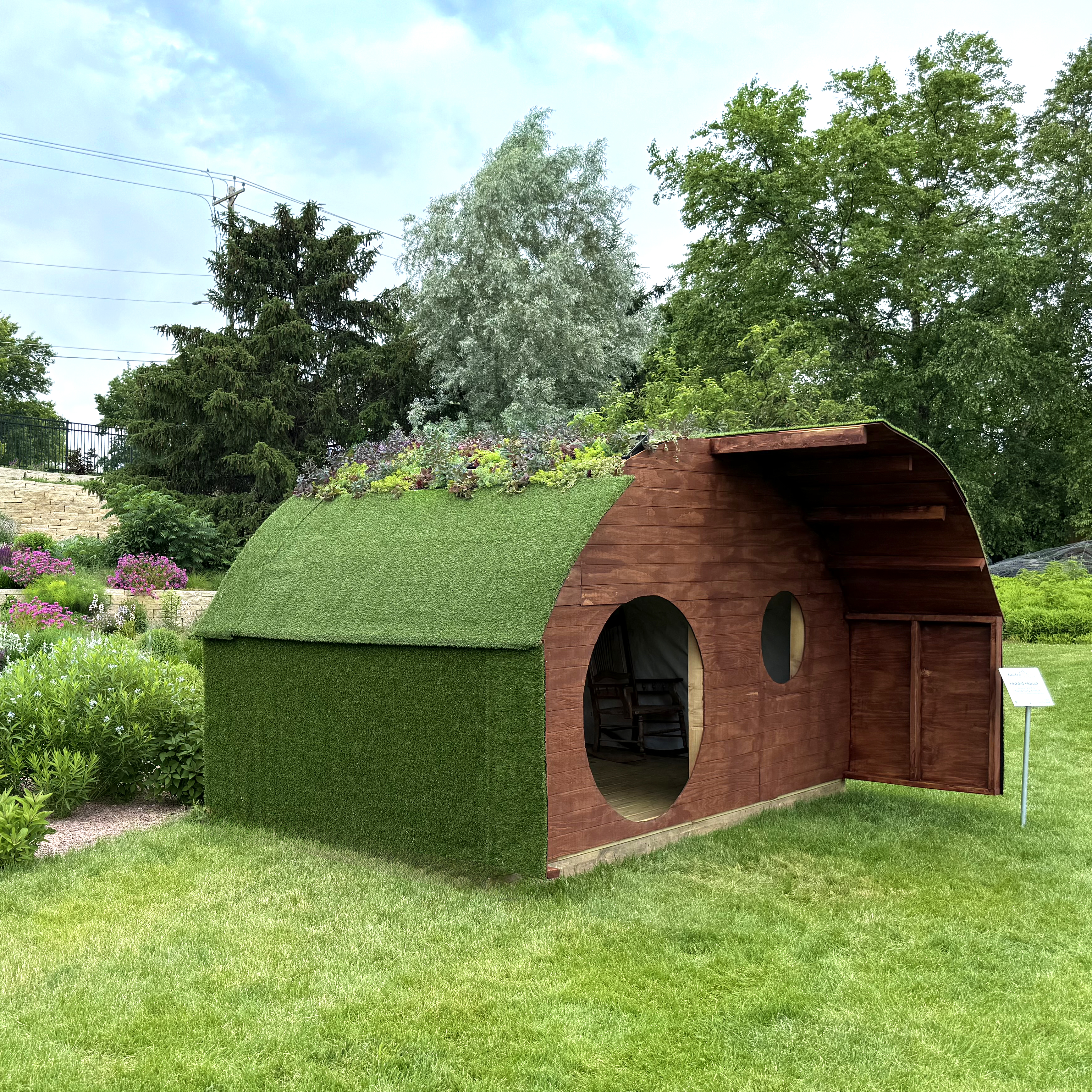 Playhouse with rounded roof covered in succulents and grass