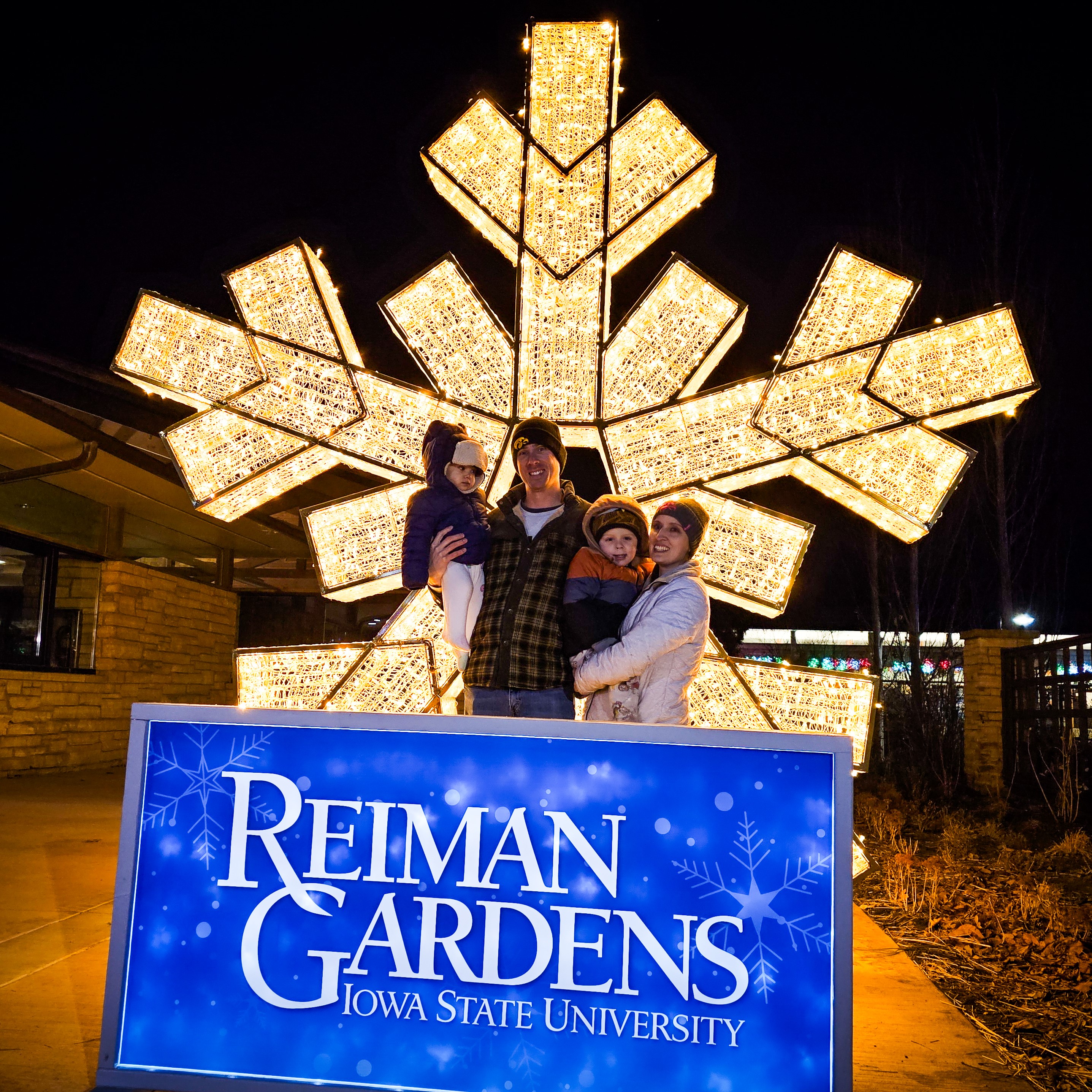 Family posing in front of a giant lighted snowflake