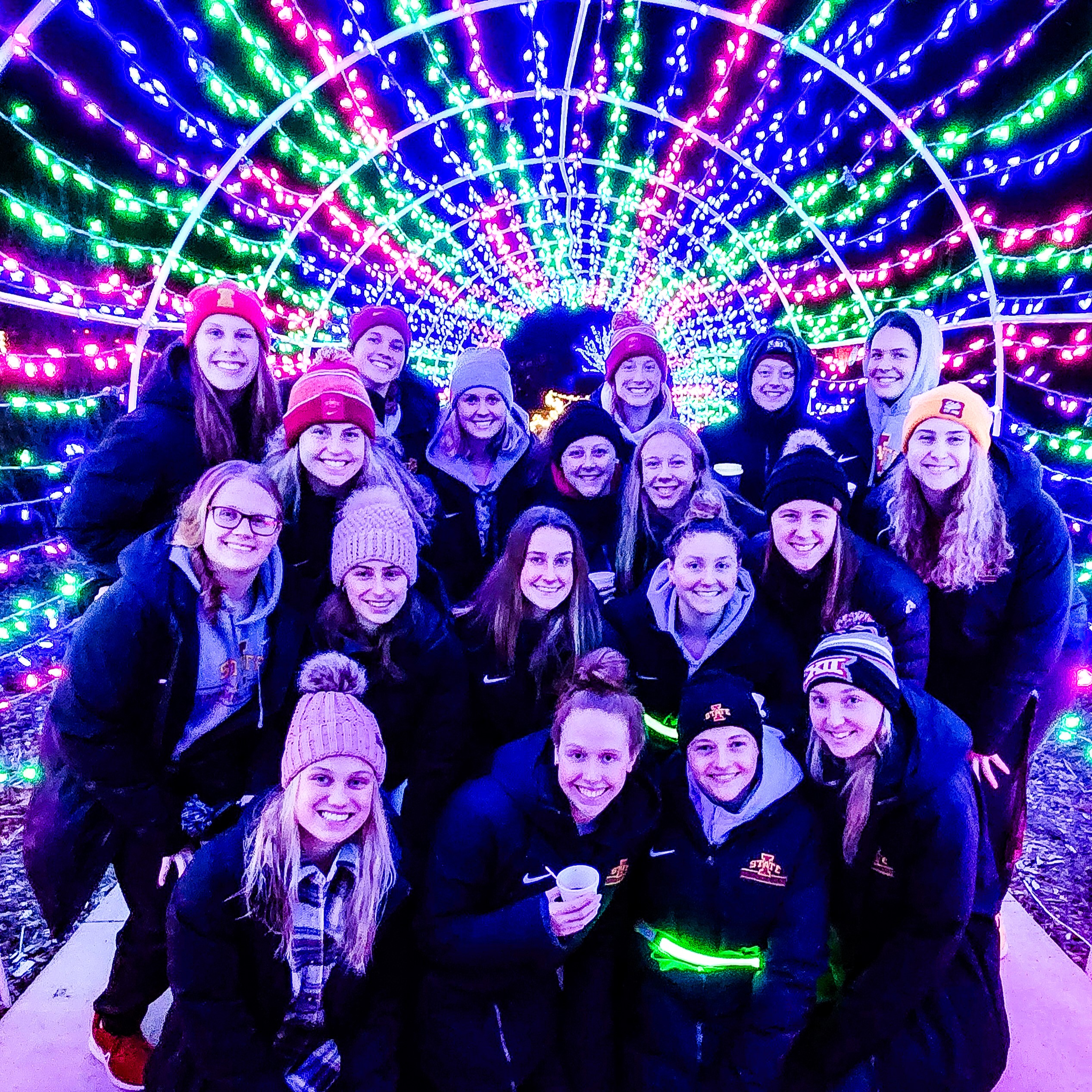 Group of college students posing in a lighted tunnel