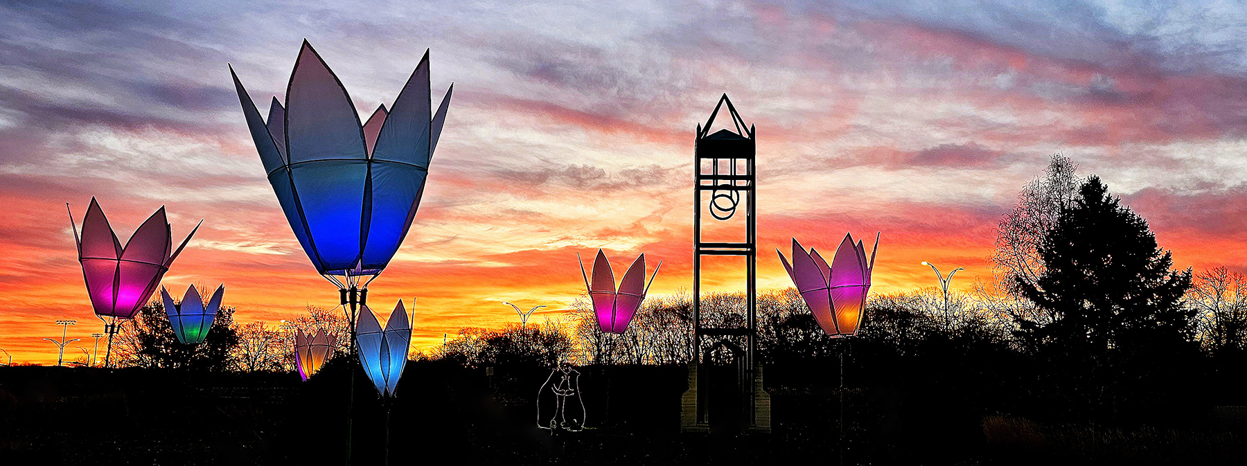 Sunset with a campanile and giant color changing lighted flowers