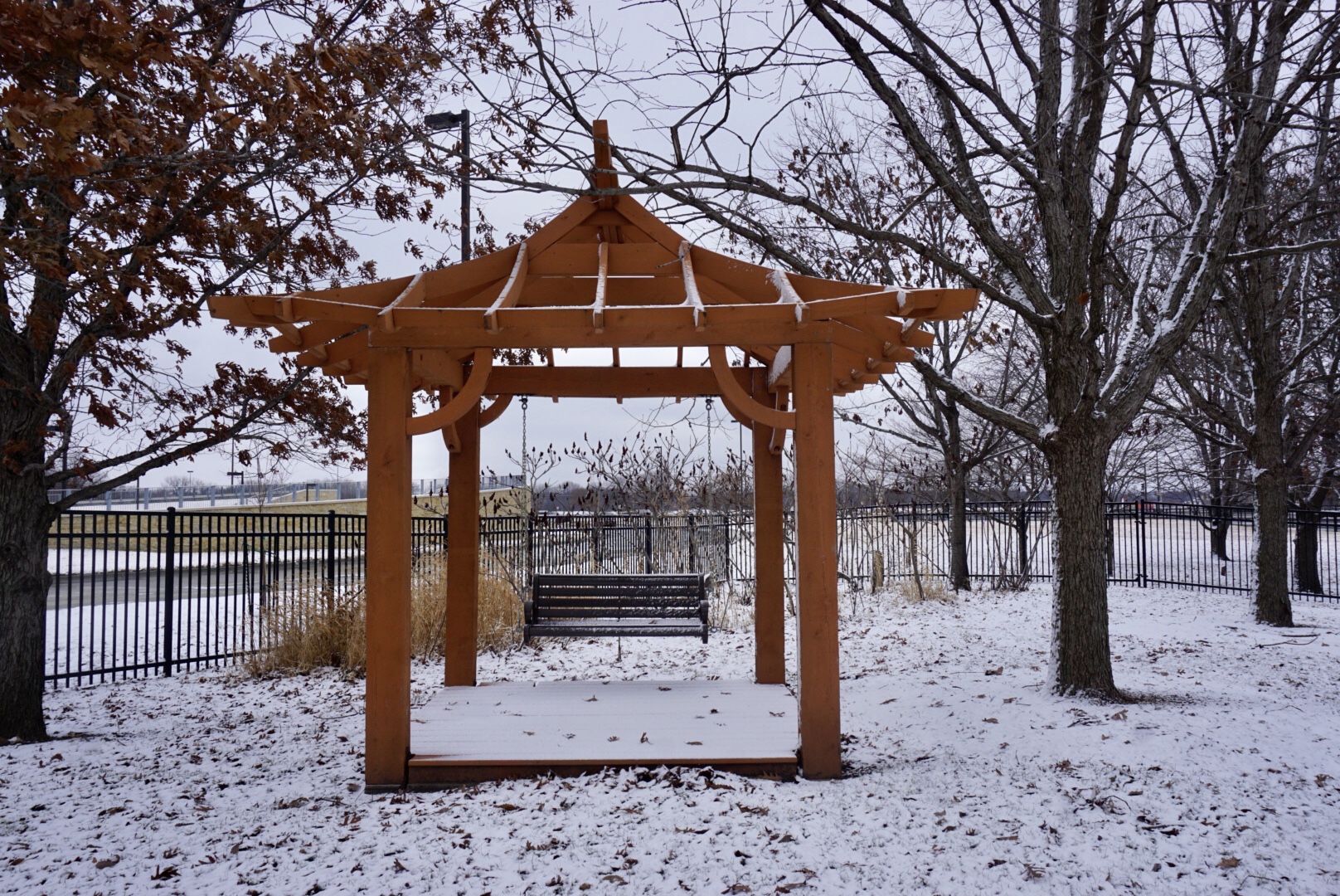 a pagoda with a swing in a garden in winter