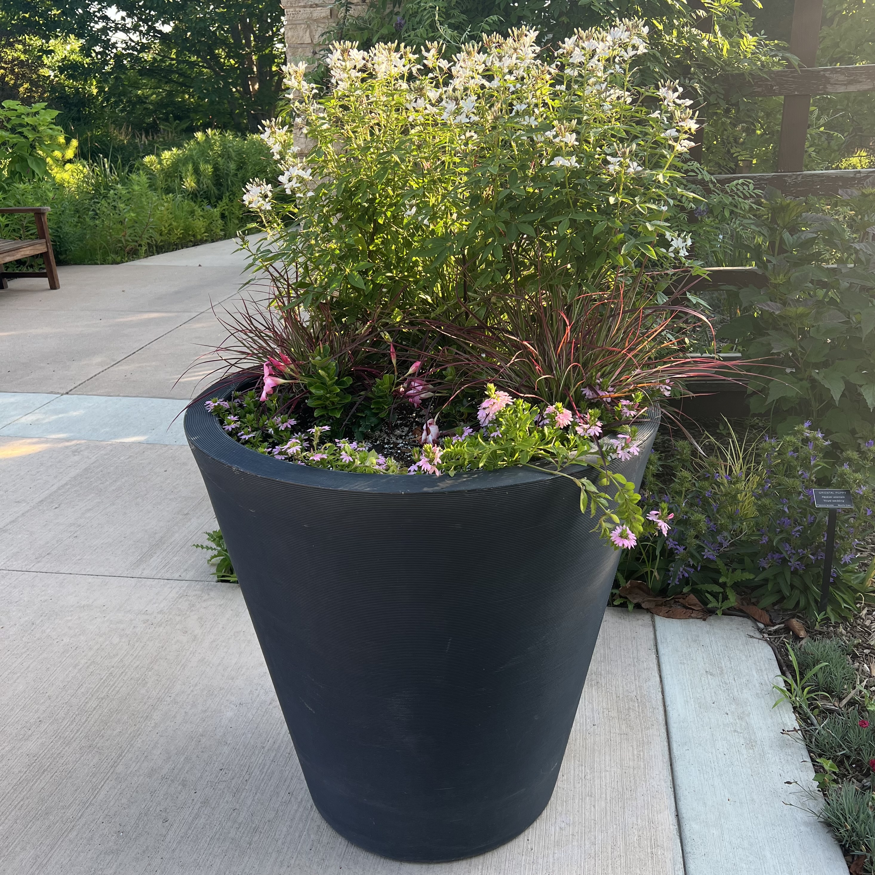 a tall container with colorful flowers