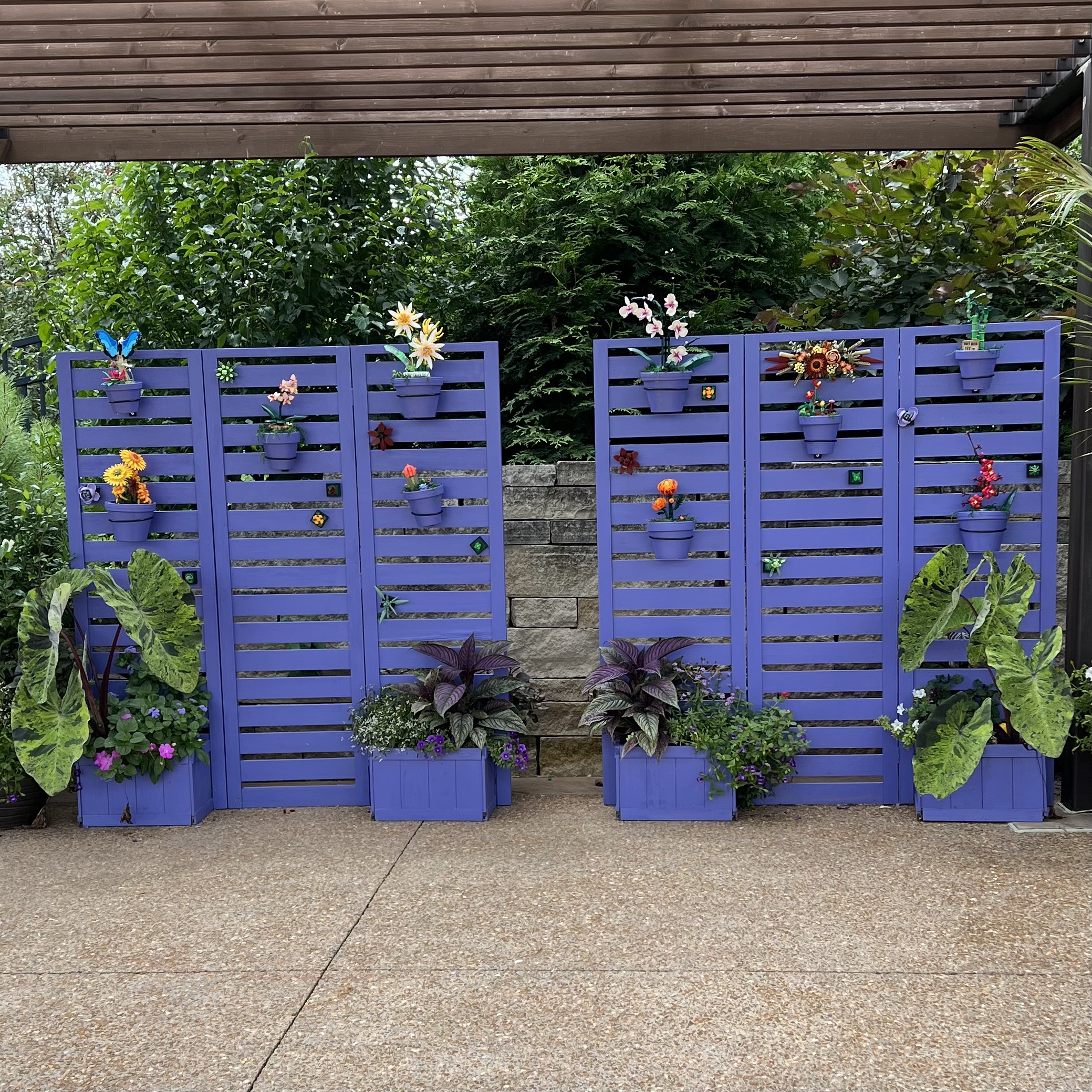 A painted display with lego flowers and planters with real flowers and foliage