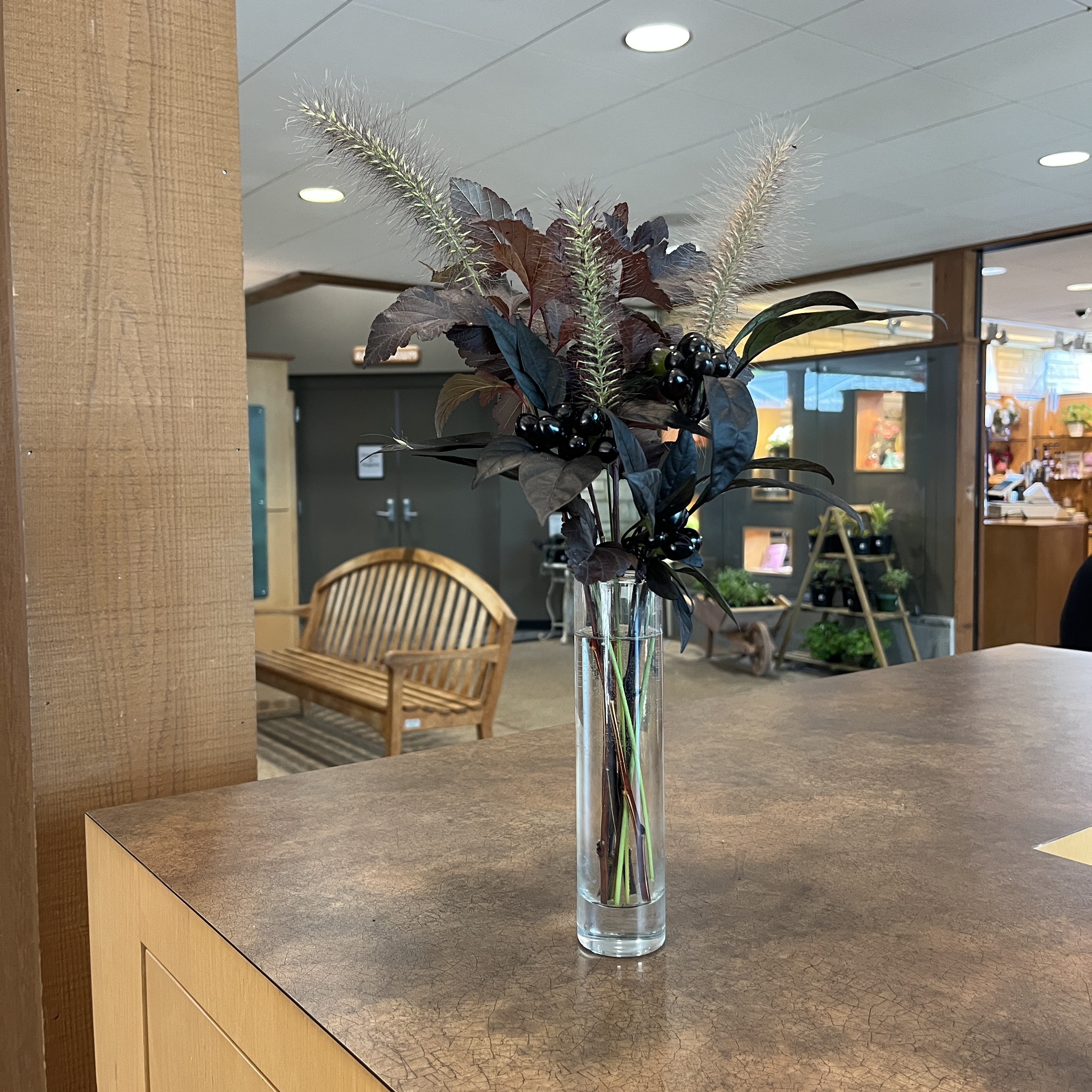 Bouquet with grasses and dark colored plants.