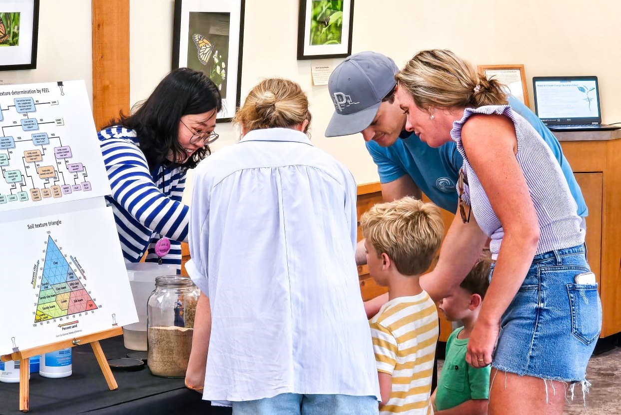 a scientist engages with a family at a tabling event