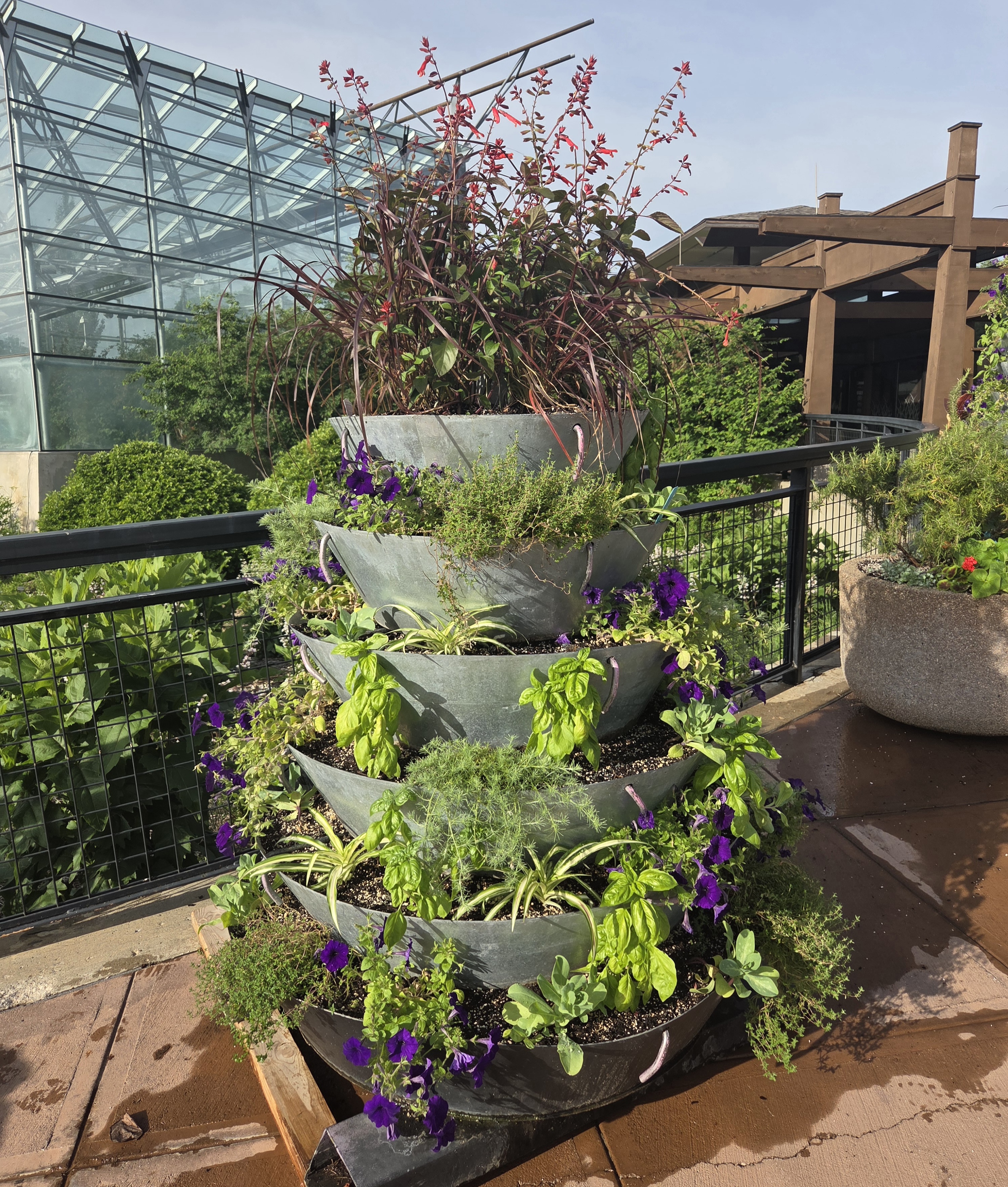 A small stacked tower of containers filled with annual plants 