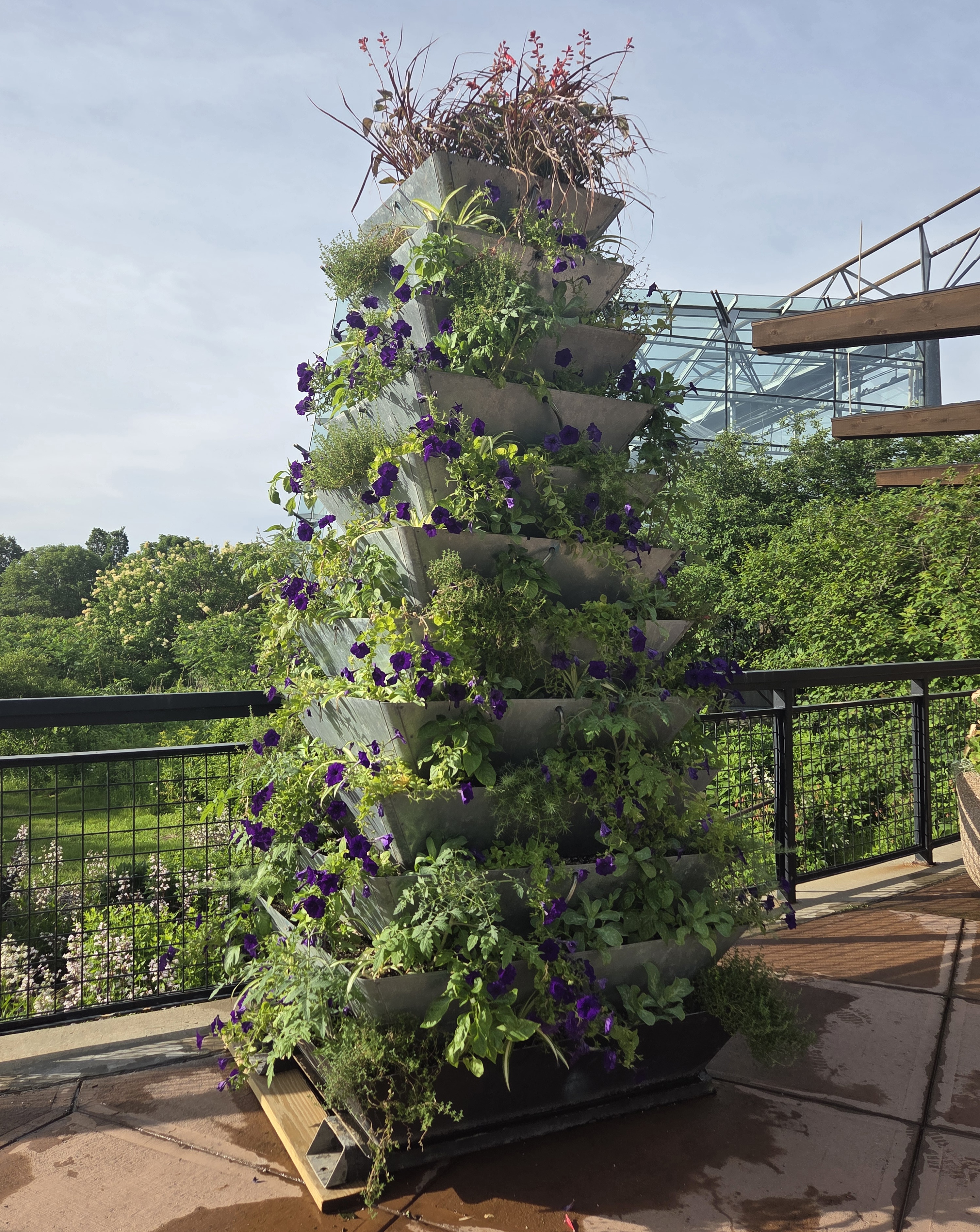 A large tower of stacked containers filled with plants 