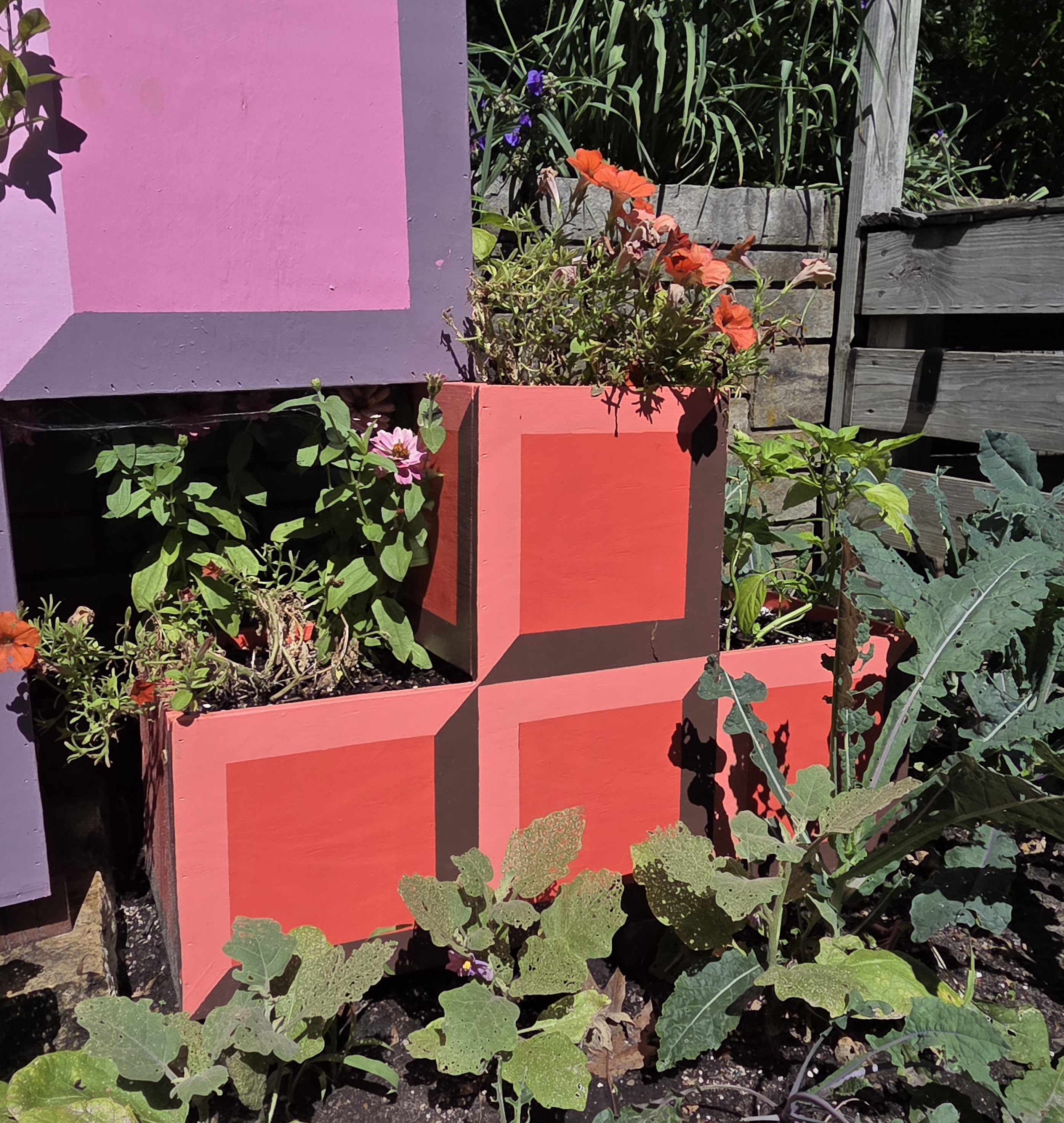 A red T-block Tetris container with Petunia, Zinnia, and Pepper