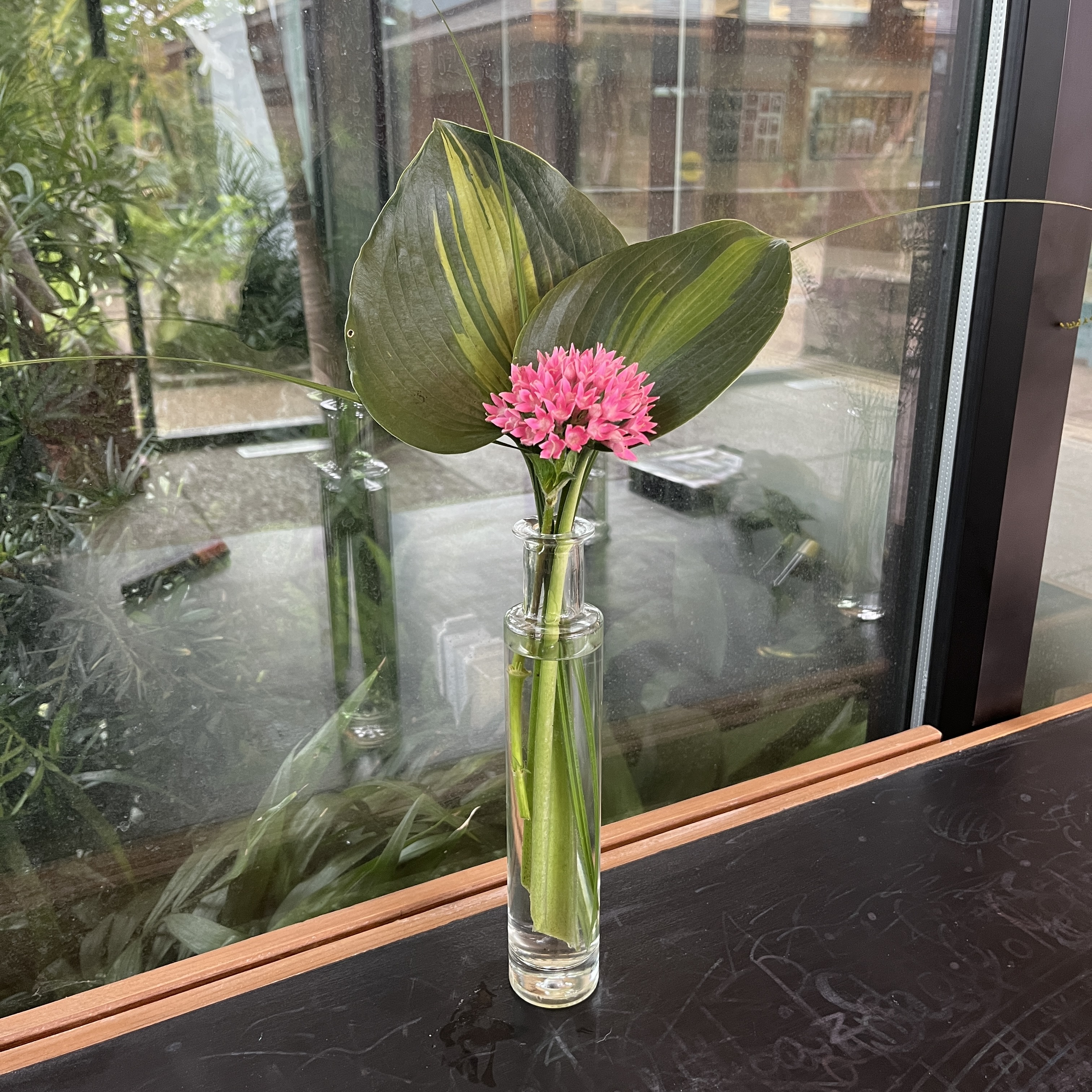 Bouquet with leaves and pink flowers.