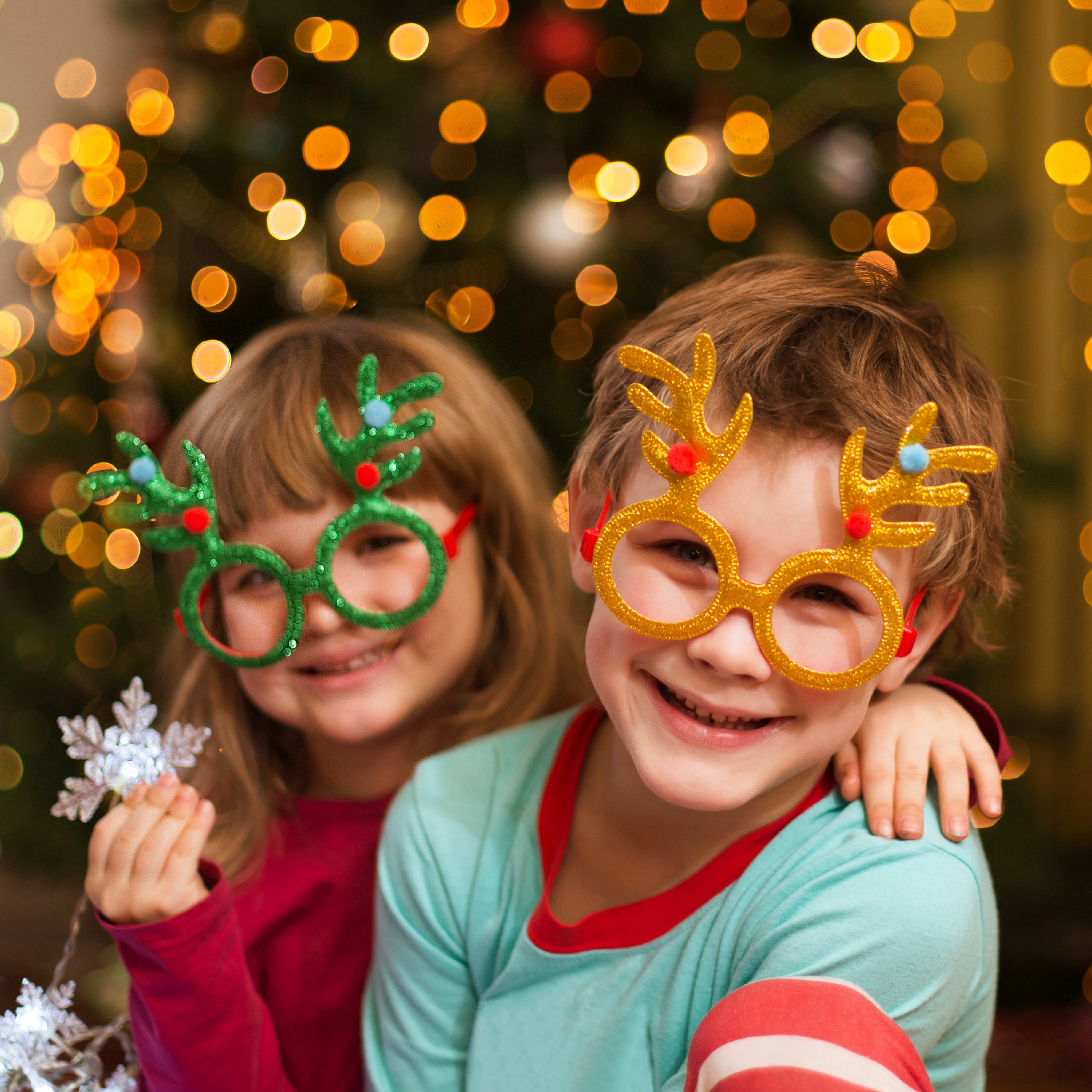 Children with reindeer glasses and snowflakes pose for photo