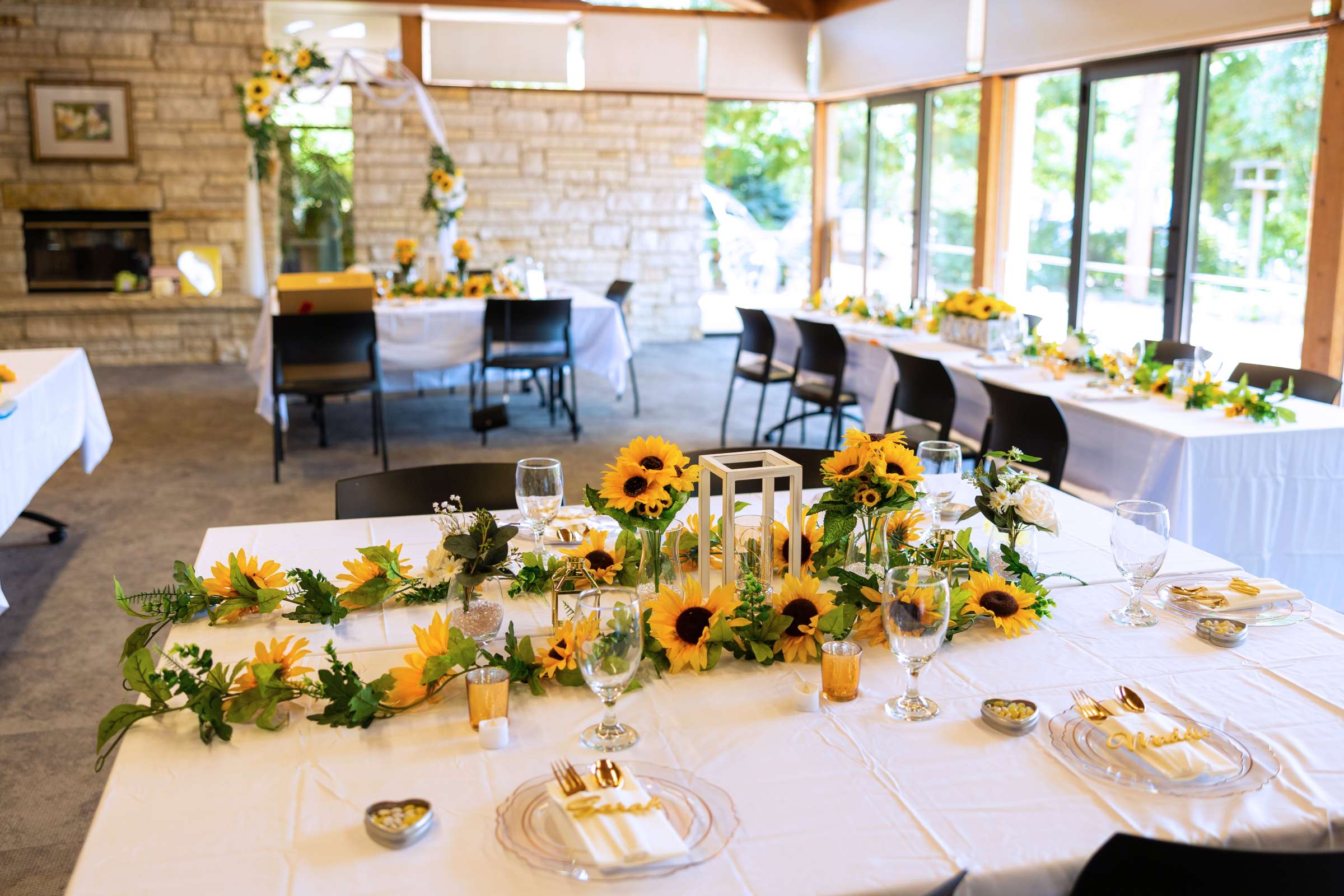 Room set for wedding reception with sunflowers on tables