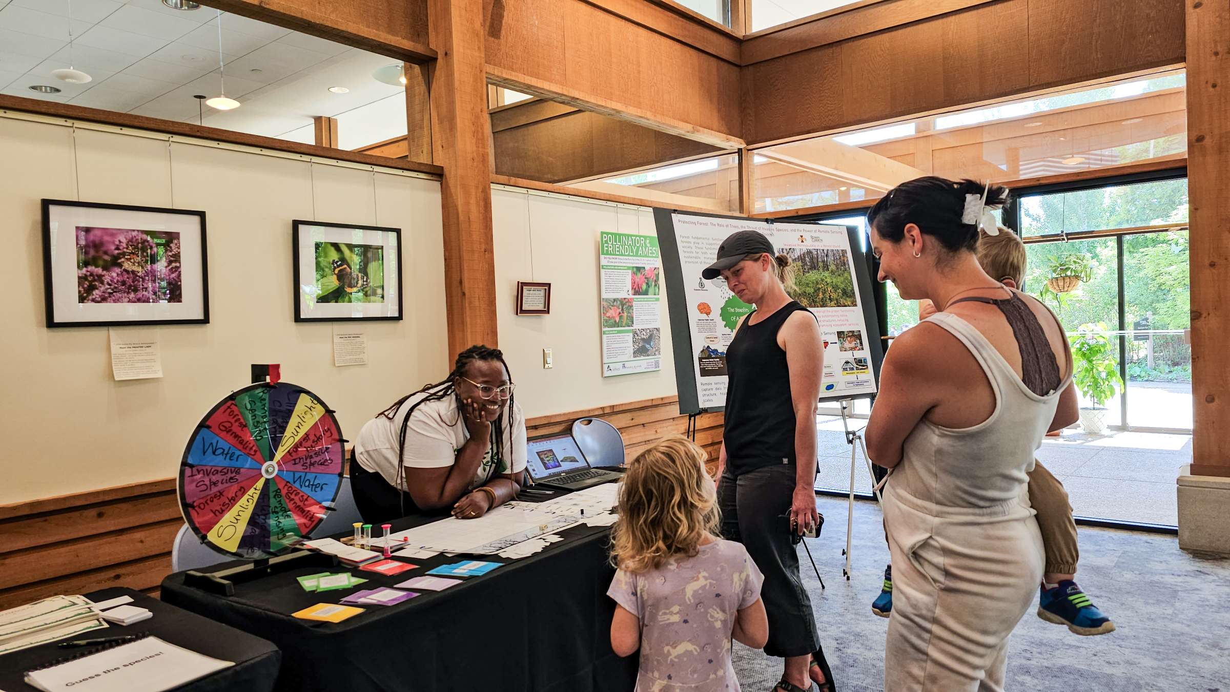 A Reiman Gardens' Science Communication Fellow leads an activity for a mixed age group at a Meet-A-Scientist program.