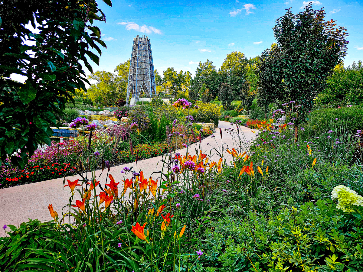 a vista of a curved garden path leading to a tall tower