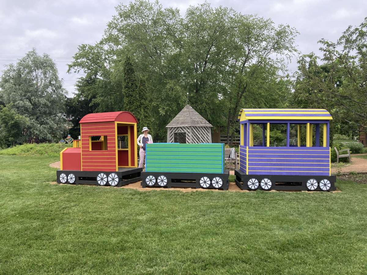 a colorful life-size three-car train in a children's garden