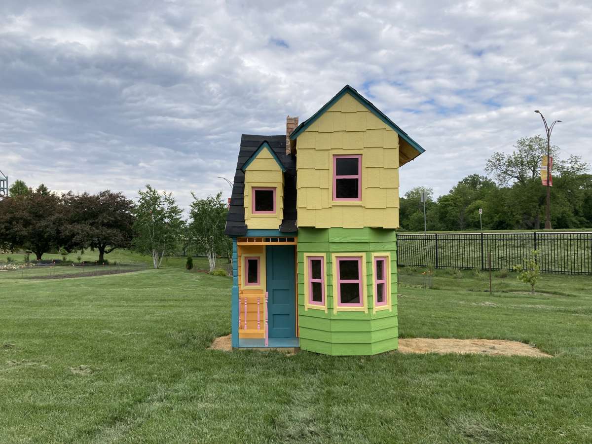 a colorful stacked house front façade set amidst a garden