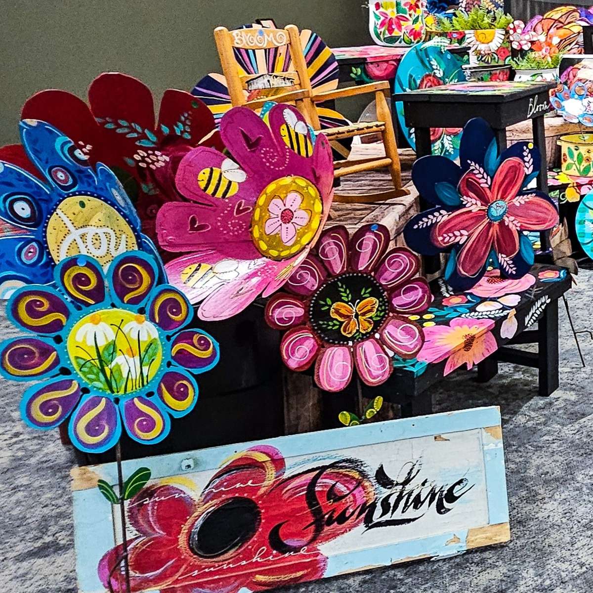 Painted metal artwork flowers on display at an art show