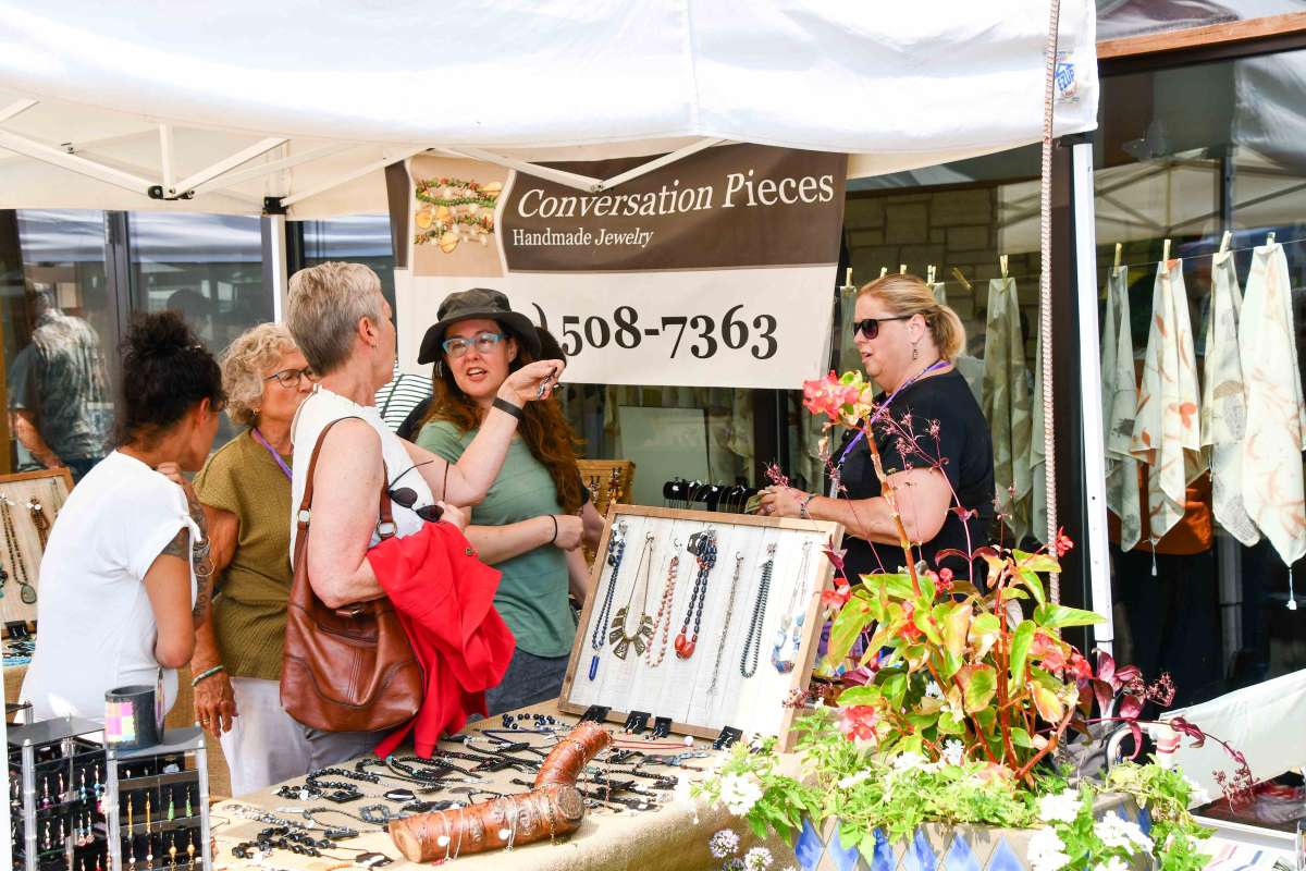 Women shopping jewelry at an outdoor art fair