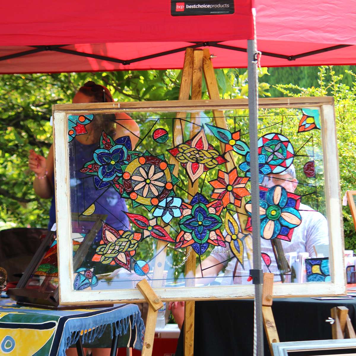 A stained glass panel on display at an outdoor art fair