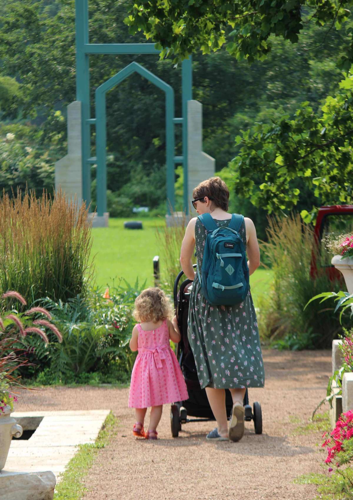 Woman and child walking in a public garden near a campanile