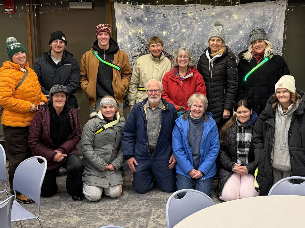 A group of volunteers poses for a photo before working at a holiday light show