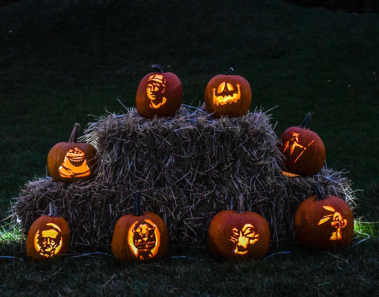 Lit Jack-o-lanterns on hay bales