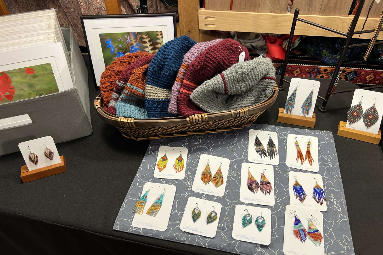 A selection of handmade earrings and crocheted hats