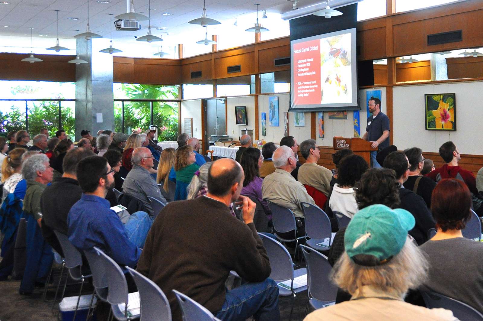People watching a presentation at a conference on insects