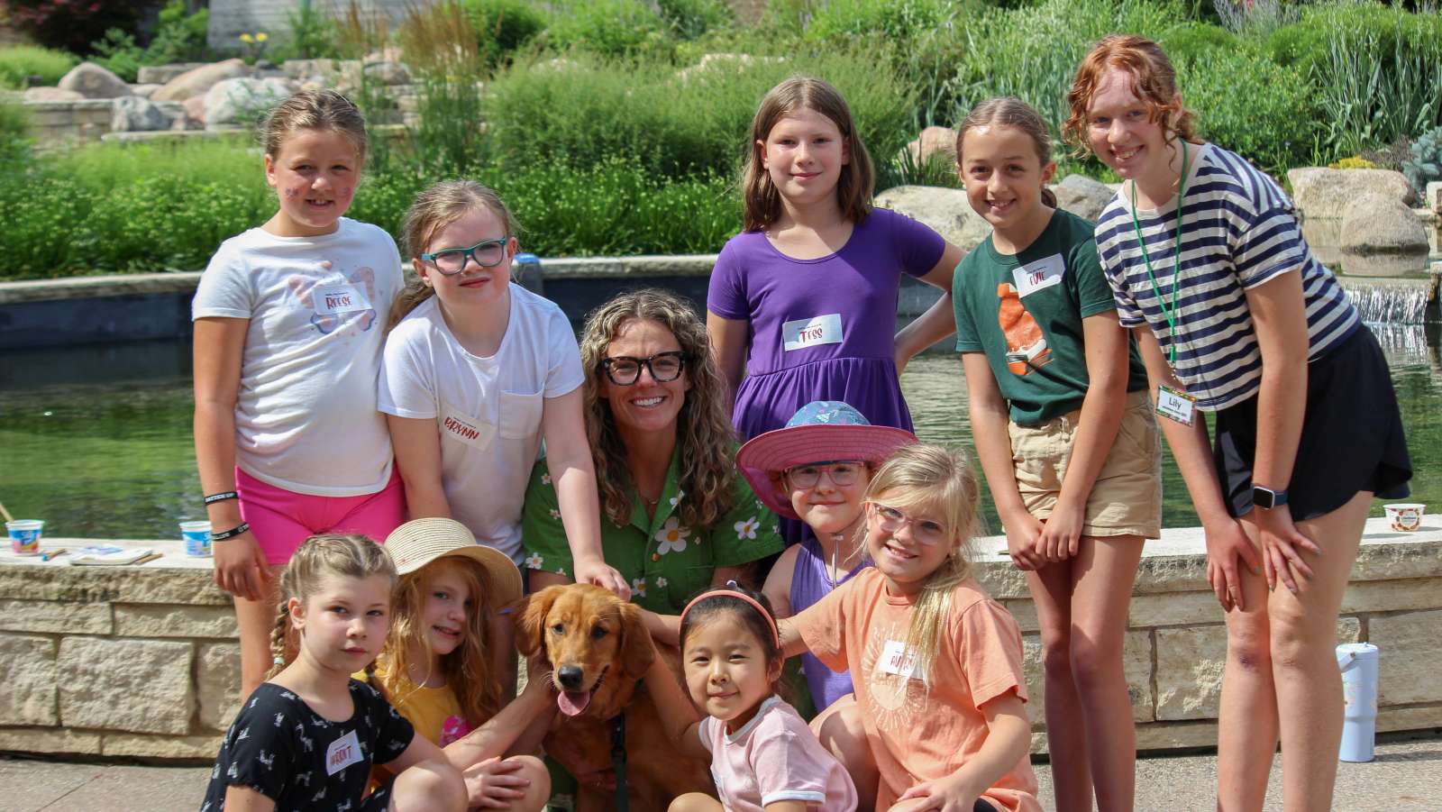 Young girls pose with a dog at a day camp