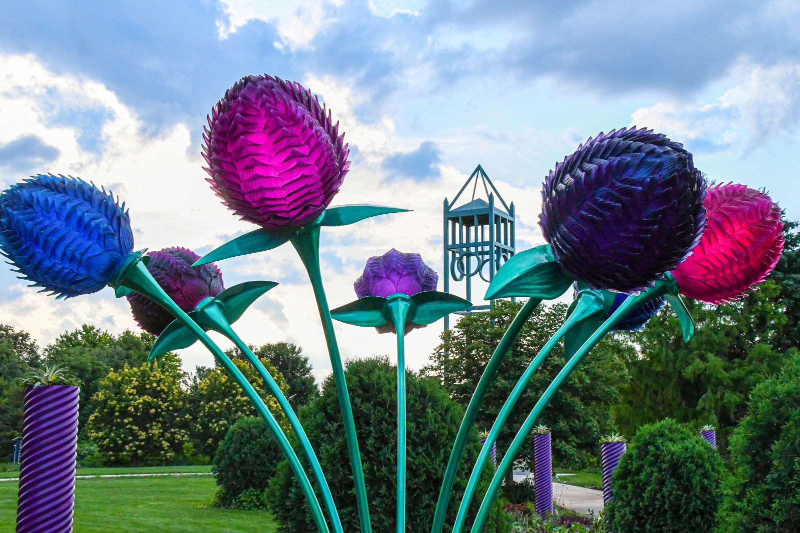 Sculpture of giant gomphrena flowers on display in a public garden